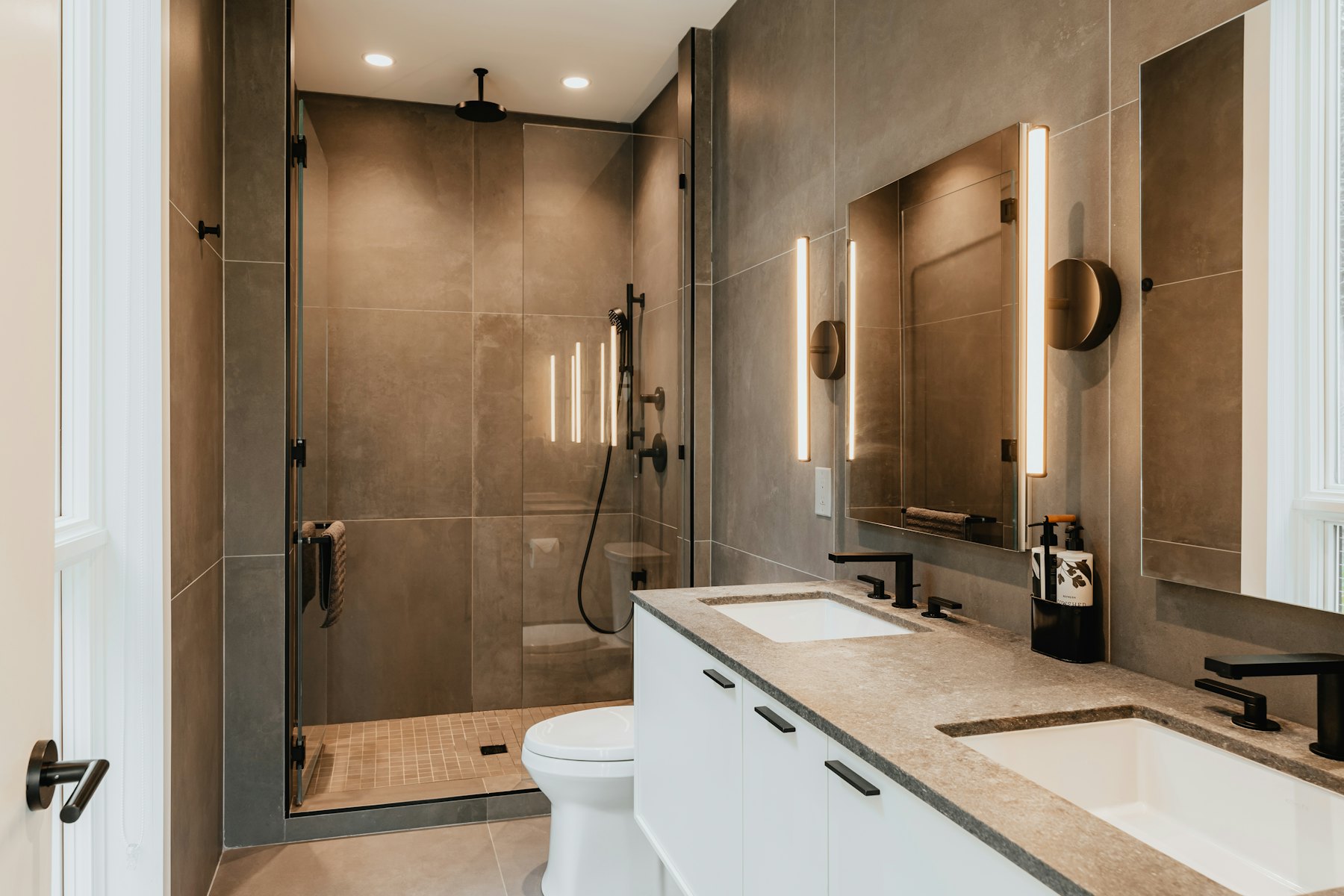 Bathroom with a glass shower enclosure and warm stone tile